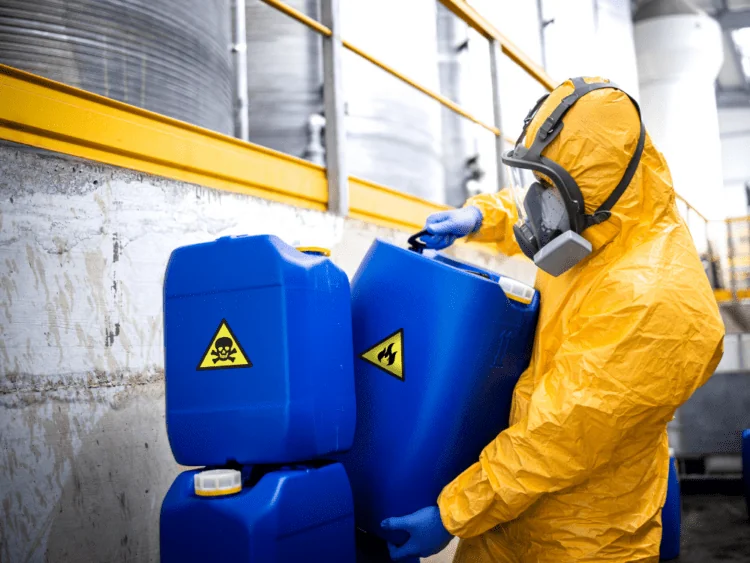 A worker handling sensitive chemicals with PPE.